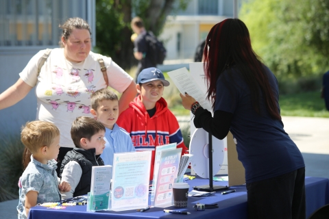 Women showing kids tabling flyer